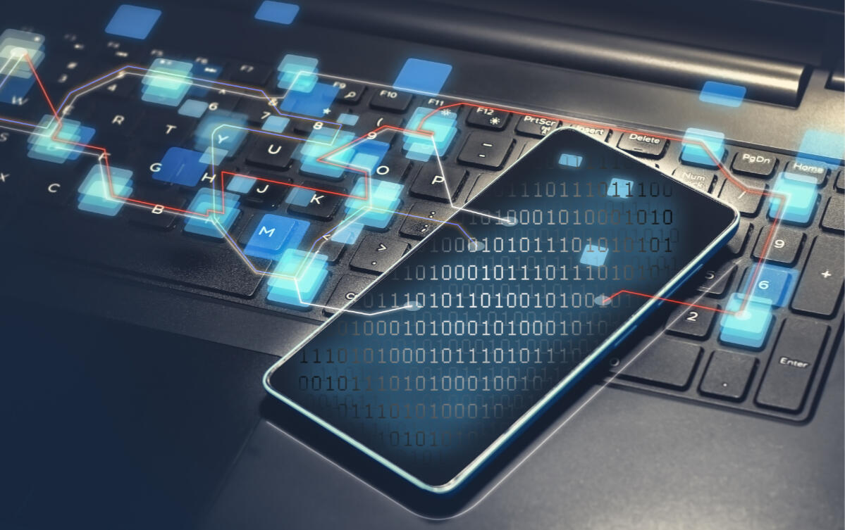 Smartphone liegt auf Tastatur und Daten werden gelesen